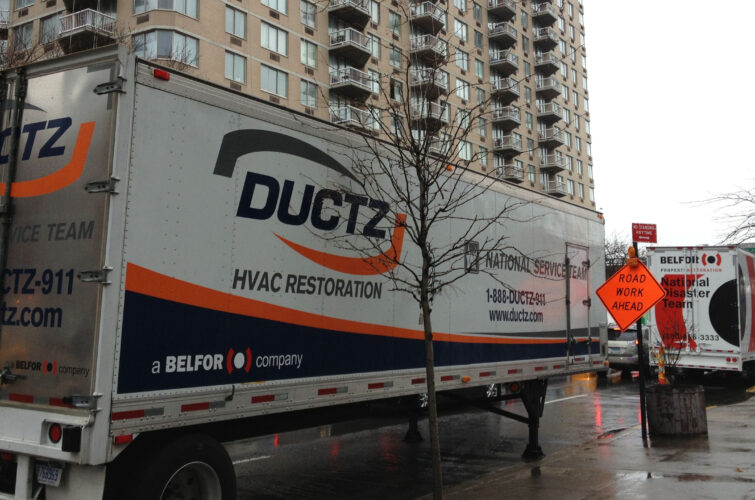 A DUCTZ trailer parked outside a city apartment complex.