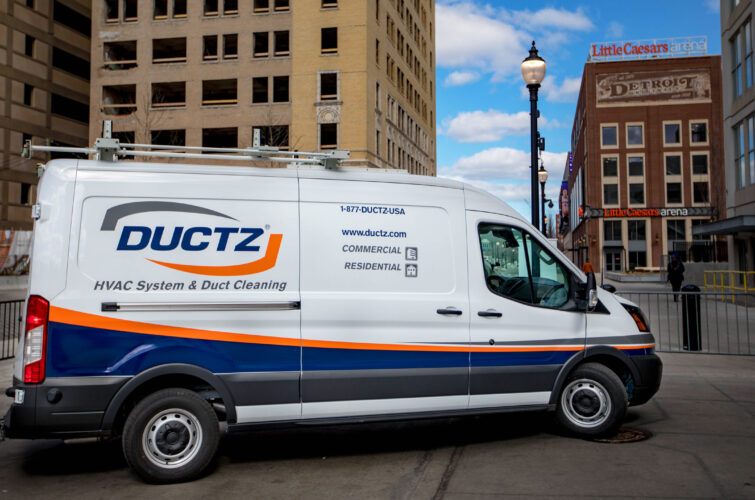 A DUCTZ company truck parked in front of large buildings in Detroit.