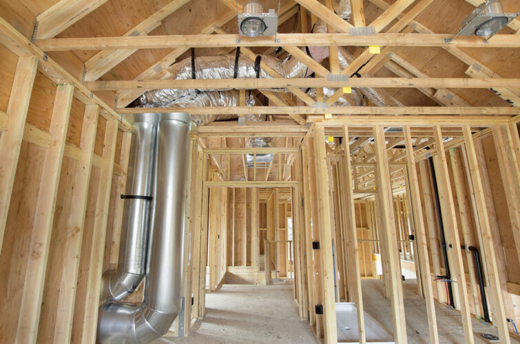 Interior view of a home under construction with air vents and ducts exposed.