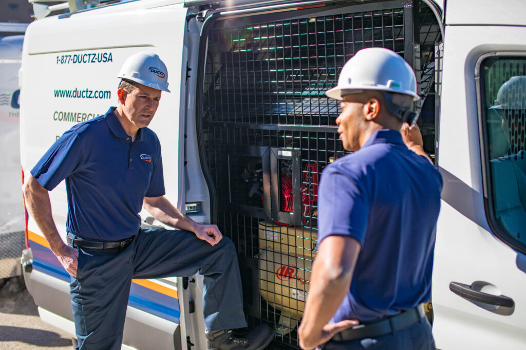 Closeup shot of two DUCTZ technicians conversating.