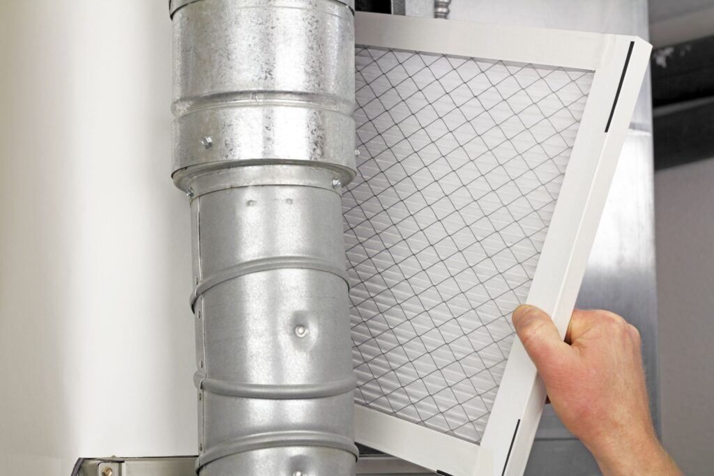 Closeup of a man installing an air duct air filter.