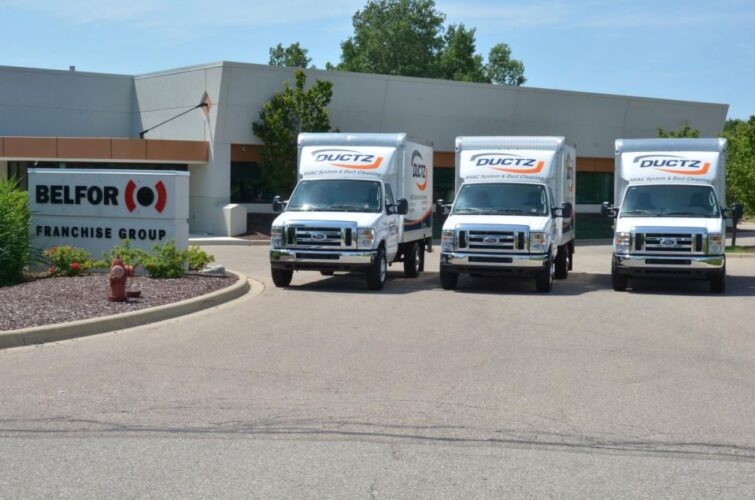 Three DUCTZ commercial trucks parked outside of Belfor franchise group.