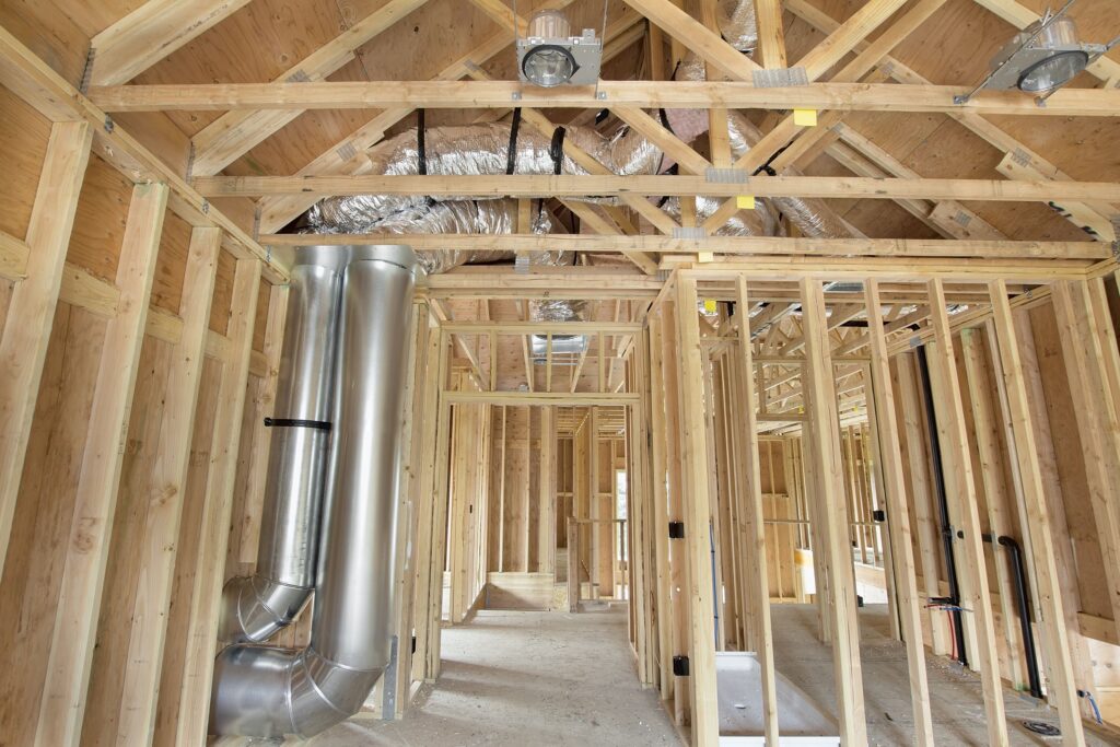 Interior view of a home under construction with air duct vents exposed.